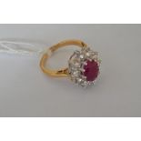 An 18ct yellow gold oval ruby and diamond cluster ring, ruby approx. 2.25ct, diamonds approx 1.5ct
