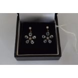 A pair of daisy style earrings set with blue topaz and diamonds