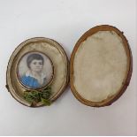 An early 19th century oval bust portrait miniature, of a child wearing a blue jacket, 3.5 x 3 cm, in