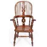 A yew and elm Windsor type kitchen armchair, the splat pierced Christmas trees, on turned legs