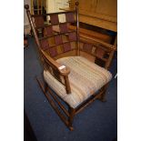 An Arts & Crafts oak rocking armchair, the back and sides with leather inset panels