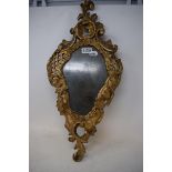 A Venetian wall mirror, of shaped rococo form, the glass plate decorated a gentleman, 60 x 28 cm