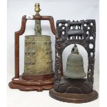 A bronze bell, in a carved Chinese hardwood frame, on a stand, 38.5 cm high, and a Chinese