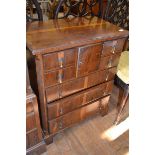 An 18th century style yew chest, incorporating a door, four short and four long drawers, flanked