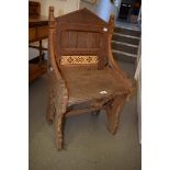A Victorian Gothic oak hall chair, the back inset two tiles, and with pierced sides joined by a