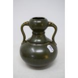A Chinese green glazed pottery double gourd vase, with twin handles, 19 cm high generally good, a
