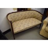 An Arts and Crafts mahogany two seater settee, with shaped arms and legs, 135 cm wide