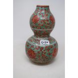 A Chinese double gourd vases, decorated foliage in red on a green ground, 24 cm high good condition