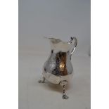A mid 18th century silver cream jug, initialled, on three pad feet, marks indistinct, and a silver
