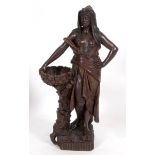 An Ernst Wahliss terracotta figure of a scantily clad lady carrying a basket, after Albin Dobrich,