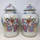 A pair of Chinese famille rose vases and covers, of baluster form, decorated figures, 41 cm high (2)