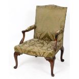 A George III style mahogany Gainsborough armchair, with leaf carved arms and cabriole legs with