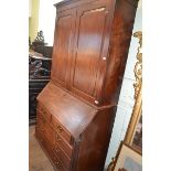 A George III mahogany bureau bookcase, having a pair of panel doors enclosing adjustable shelves,