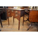 A George III oak lowboy, having three drawers above a shaped apron, on circular legs, 60 cm wide