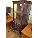 An oak display cabinet, having a glazed door above a panel door, incorporating 17th century