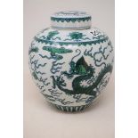 A Chinese ginger jar and cover, decorated dragons chasing flaming pearls in green and blue enamel