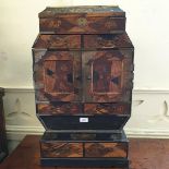 A Japanese parquetry and black lacquered table cabinet, with an arrangement of drawers, 44.5 cm
