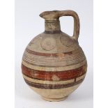 A Cypriot earthenware jug, decorated circles and bands of lines, 22 cm high, probably 7th century