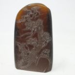 A Chinese hardstone carved pebble, decorated two figures below a knarled tree, 8 cm high