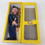 A Pelham puppet, SN Policeman, in a yellow cellophane box