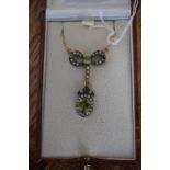 A necklace set with peridot and diamonds in a bow top design