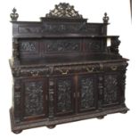 A late 19th century Italian breakfront walnut cabinet, carved in hide relief figures, mythical