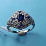 A Victorian style platinum, sapphire and diamond set ring with a central oval-cut sapphire. The