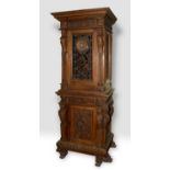 A late 19th/early 20th century walnut cabinet on stand, carved figural caryatids, bell flowers and