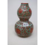 A Chinese double gourd vases, decorated foliage in red on a green ground, 24 cm high
