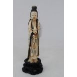 An early 20th century Chinese carved, stained and painted ivory figure, of a lady holding beads