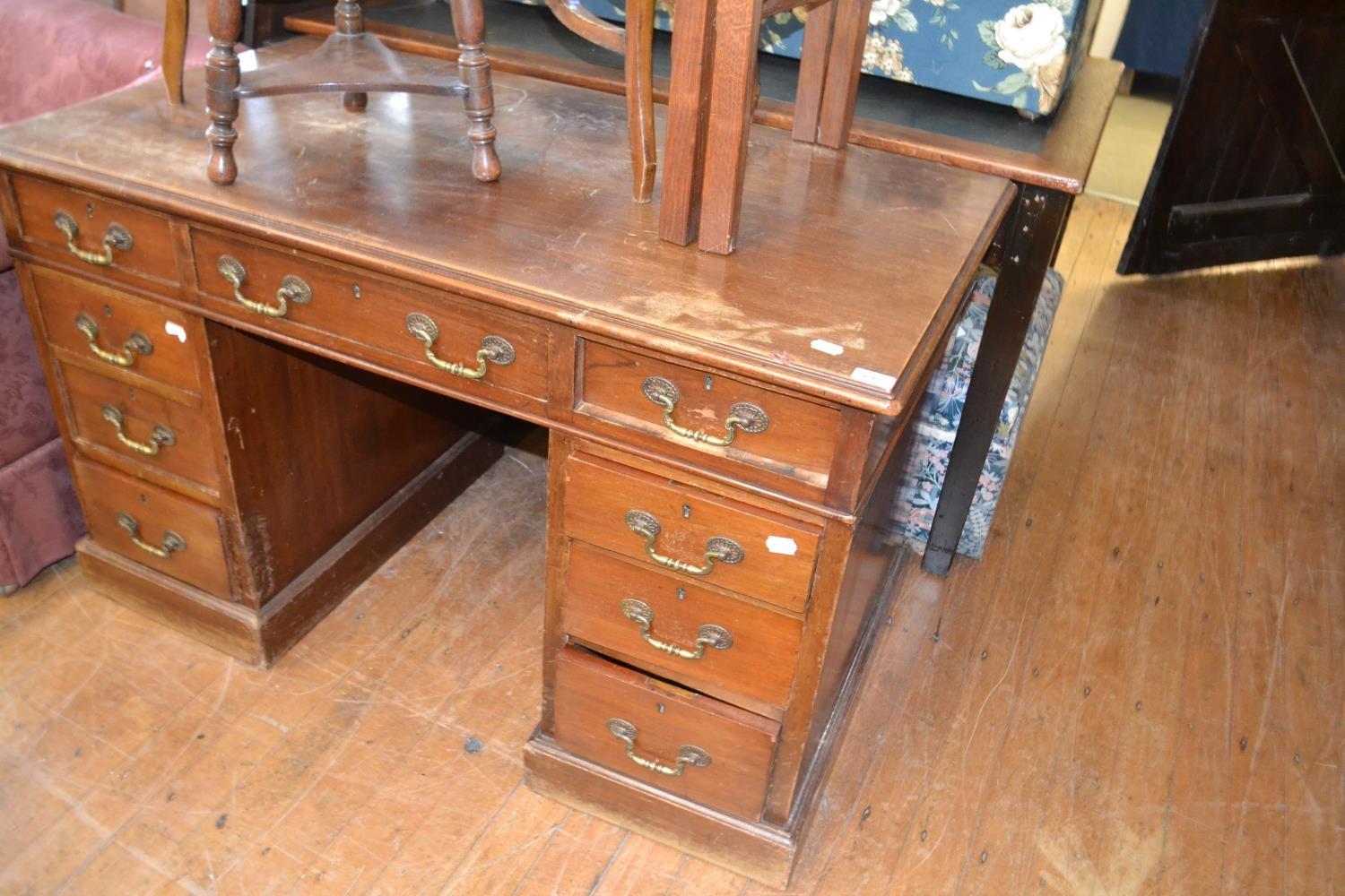 A mahogany pedestal desk, having an arrangement of nine drawers, 122 cm wide