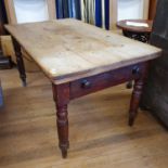 A late Victorian scrubbed top pine kitchen table, on turned legs, 135 cm wide