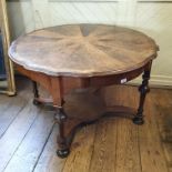 A walnut two tier occasional table, of shaped circular form, with a segmented top, 110 cm diameter