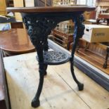 A cast iron pub type table, with an oak top, 61 cm diameter