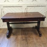 An early Victorian rosewood library table, with two frieze drawers, on end supports joined by a