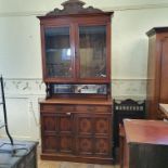 A walnut bookcase on cupboard, having a pair of bar glazed doors above two frieze drawers with a