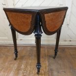 A late Victorian ebonised drop leaf table, the leather inset top on tapering fluted legs, 103 cm