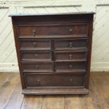 An oak chest, of small proportions, having an arrangement of one long, six short, and a further long