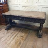 A late 19th century Anglo-Flemish oak centre table, the frieze, end supports and sledge feet