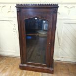 A Victorian rosewood pier style cabinet, the ogee shaped door with a glass panel, on a plinth