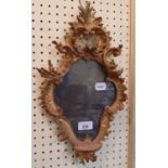A mirror, in a carved giltwood frame, 40 cm high Report by RB Some damage, loss and repairs