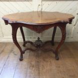 A Victorian table, of shaped oval form, veneered in burr walnut, on bell flower carved cabriole legs