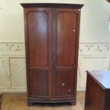 A George III style bowfront mahogany wardrobe, on bracket feet, 115 cm wide