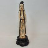 An early 20th century Chinese carved, stained and painted ivory figure, of a lady holding beads