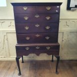 An oak chest on stand, having two short and three graduated long drawers, the stand with a frieze