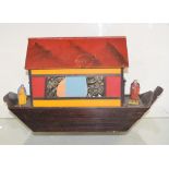 An early 20th century painted wooden model of Noah?s Ark, 34 cm high x 58 cm wide, and a