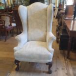 A large 18th century style upholstered wing armchair, on acanthus leaf carved cabriole front legs