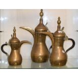 A graduated set of seven Eastern brass jugs, the largest 53 cm high, the smallest 25 cm high (7)