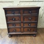 An early 18th century style oak chest, of small proportions, having four long drawers, on bun