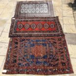 A Persian rug, 200 x 109 cm, and two other rugs (3)
